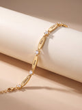 The Luna personalized name bracelet in gold on marble